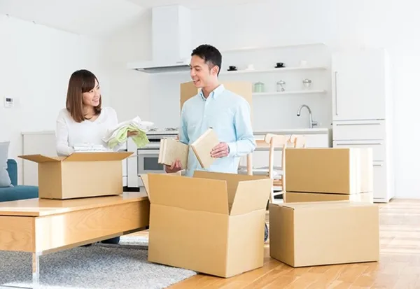年輕夫妻在客廳整理紙箱準備搬家